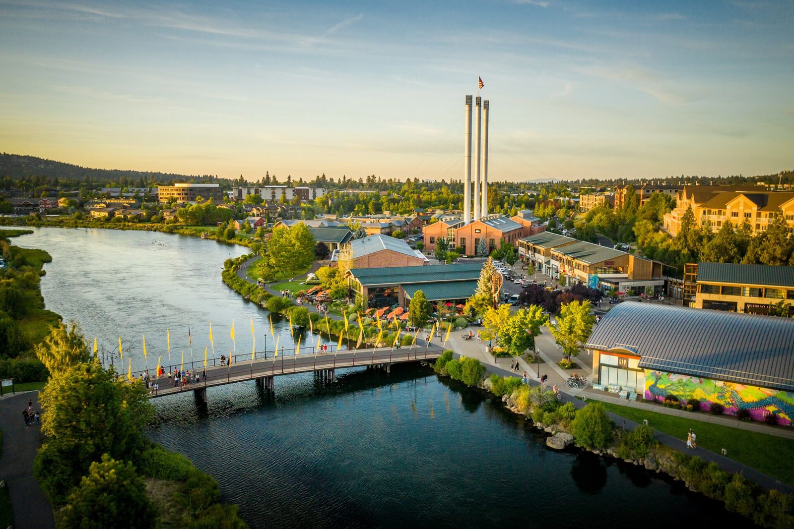 Aerial view of Bend's Old Mill District along the Deschutes River with its three smokestacks