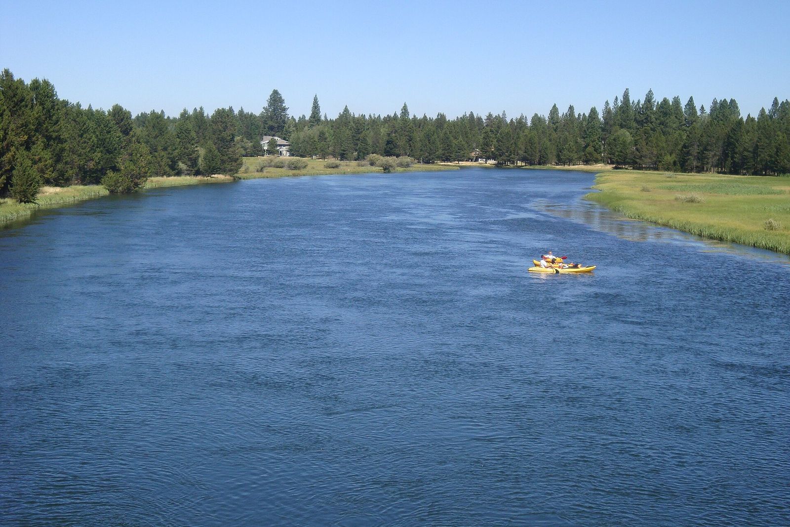 A raft floating down the wide Deschutes River through Sunriver