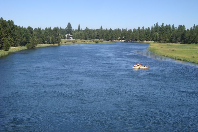 A raft floating down the wide Deschutes River through Sunriver