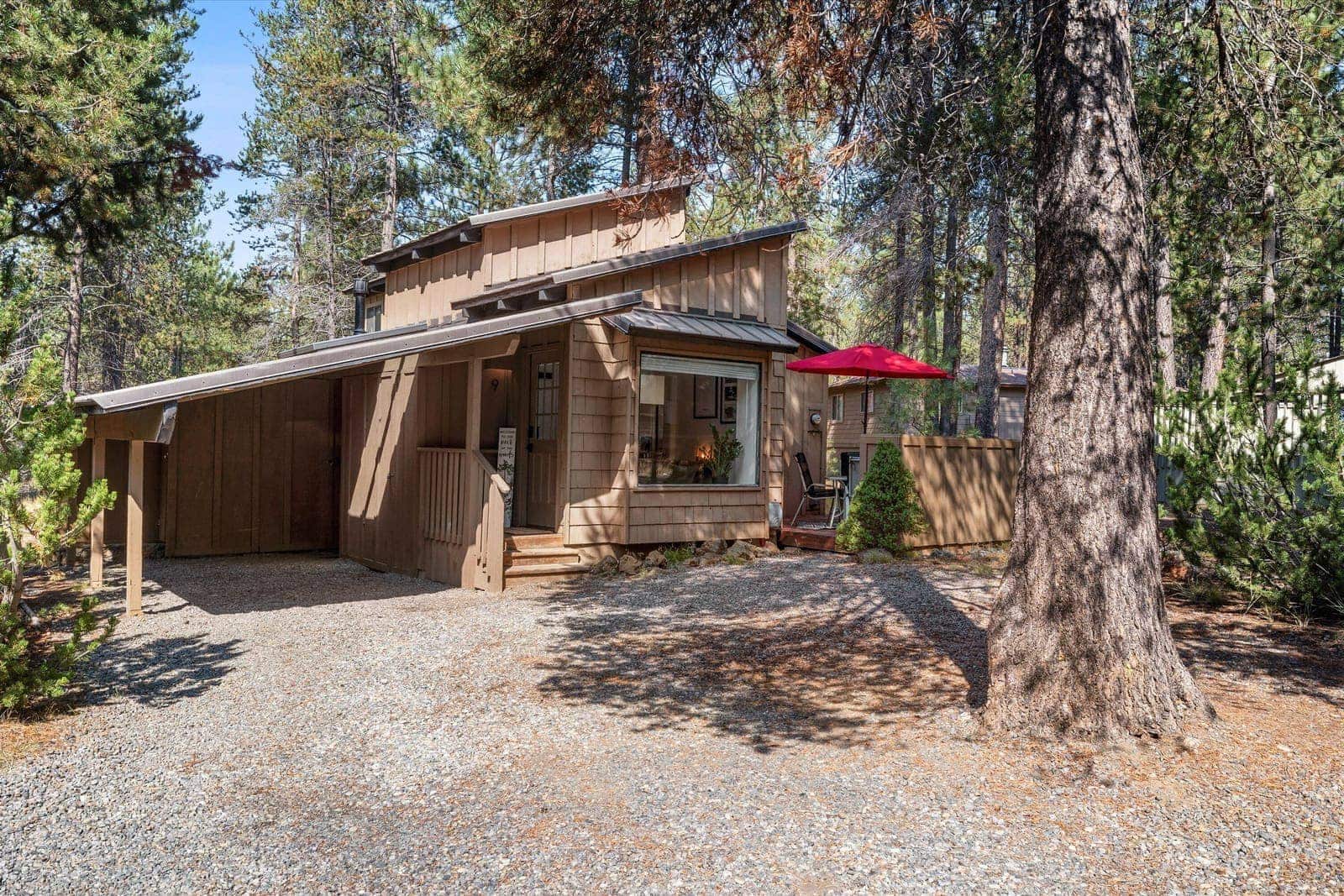 The cabin from the driveway, a shingled Sunriver chalet set among ponderosa pines